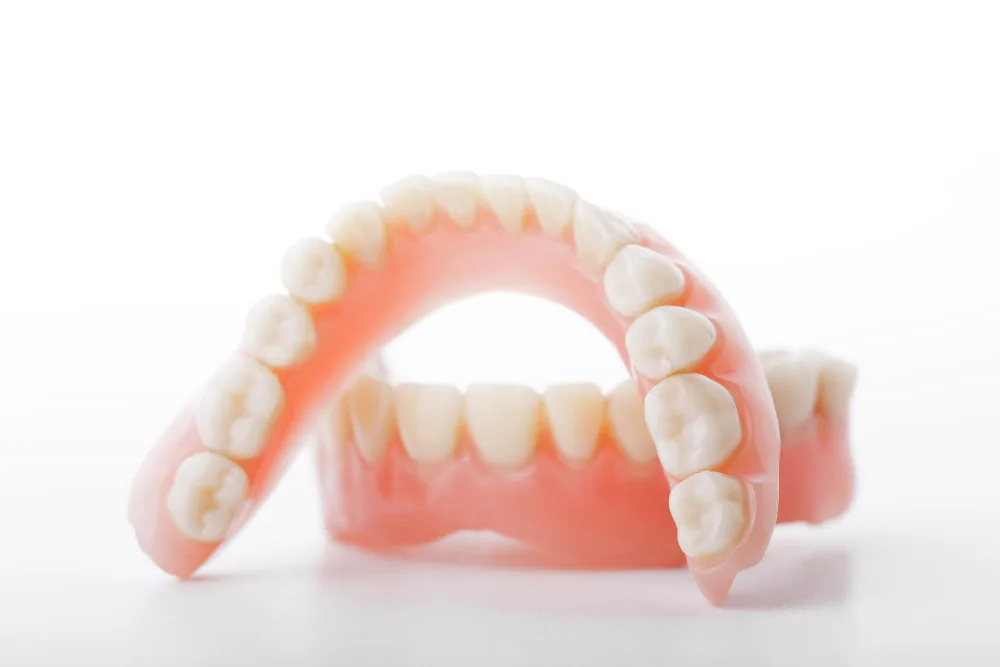 Full upper and lower dentures, often the first step on the path from dentures to dental implants