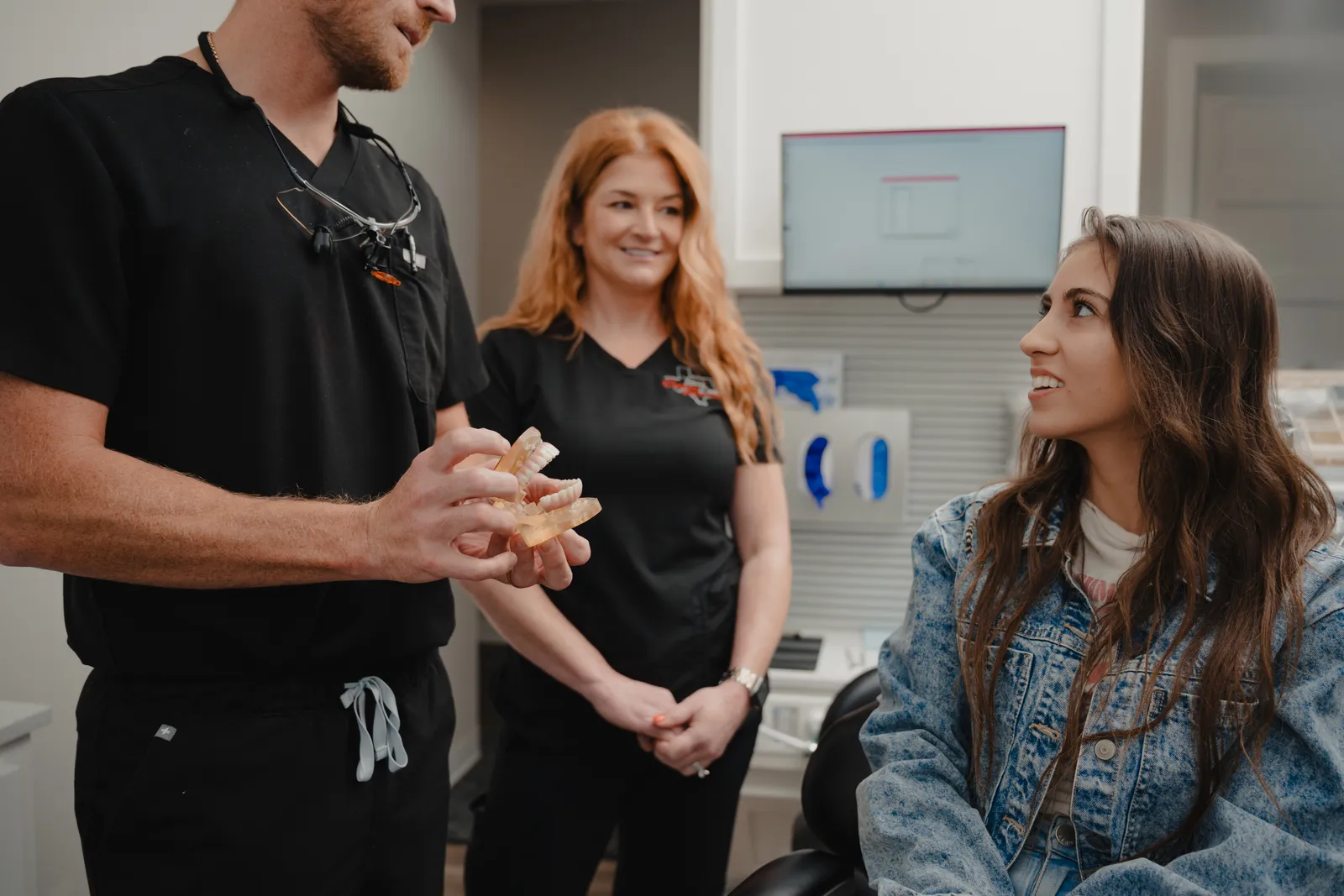 Dentist using a dental model to explain bone and implant treatment options to a patient